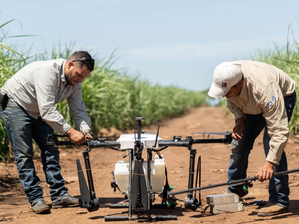 photo of two people working on agricultural drone